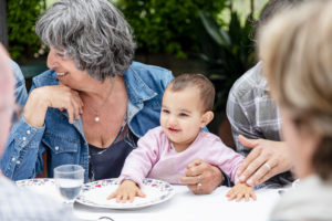 Grandmother with granddaughter on lap at outdoor family lunch, Florence, Italy Grandmother with granddaughter on lap at outdoor family lunch, Florence, Italy